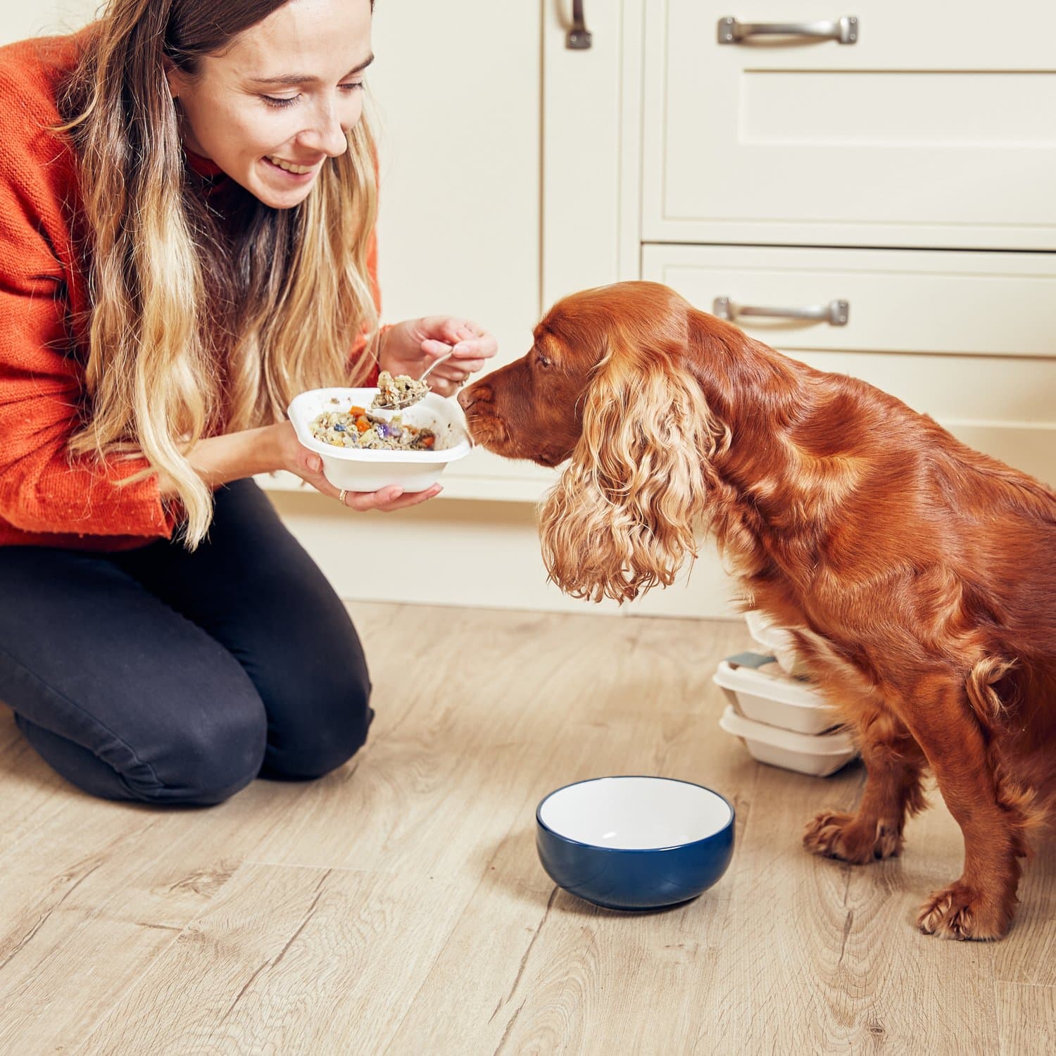 Becci feeding Crumble on the kitchen floor